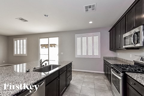 A kitchen with granite countertops and stainless steel appliances.