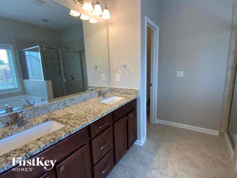 A bathroom with a marble countertop and a large mirror.
