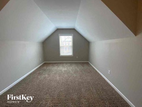 A room with a carpeted floor and a window.