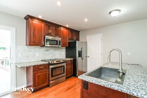 A kitchen with brown cabinets and a granite countertop.