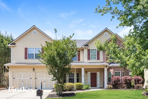 A two-story house with a garage and a front yard.