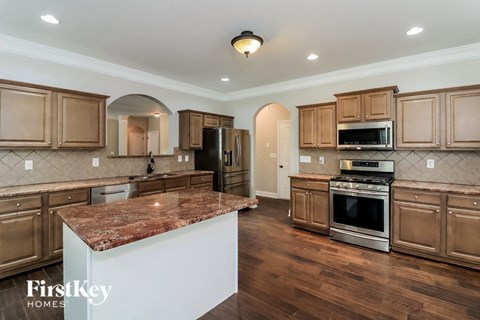 A kitchen with wooden cabinets and a marble countertop.