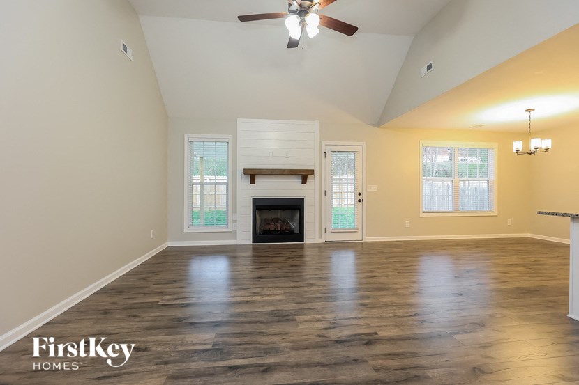 A spacious room with a fireplace and a ceiling fan.