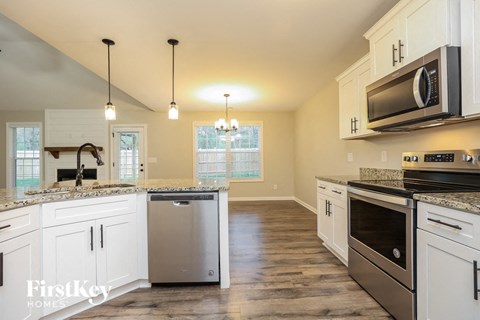 A kitchen with white cabinets and a granite countertop.