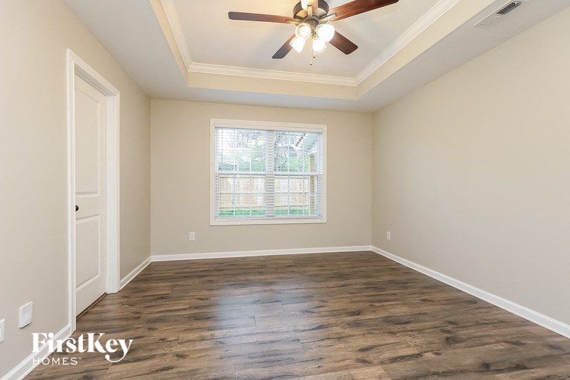 A room with wooden floors and a ceiling fan.