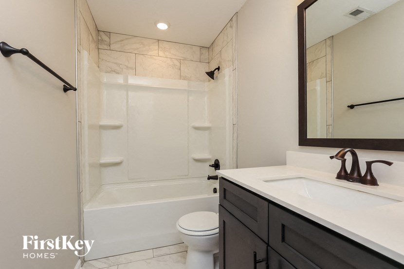 A bathroom with a white toilet, a white sink, and a white bathtub.
