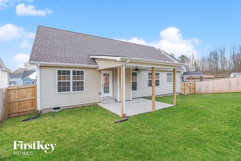 A house with a porch and a fence in the yard.