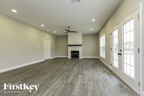 A spacious room with a fireplace and a ceiling fan.