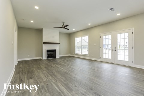 A spacious room with a fireplace and a ceiling fan.