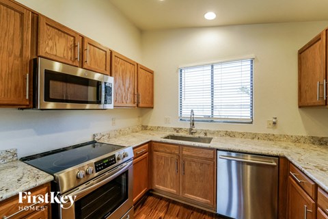 a kitchen with wooden cabinets and stainless steel appliances