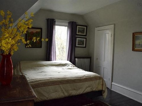 a bedroom with a bed and a vase of flowers