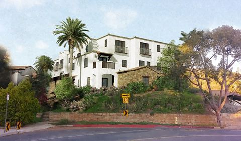an apartment building on a hill with palm trees