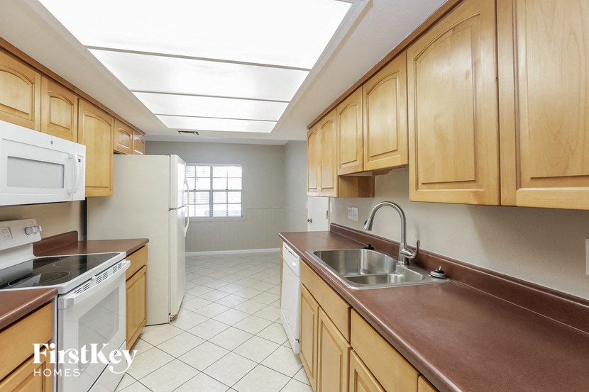 a kitchen with wooden cabinets and white appliances