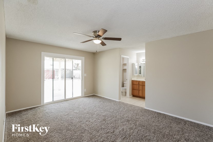 an empty living room with a ceiling fan