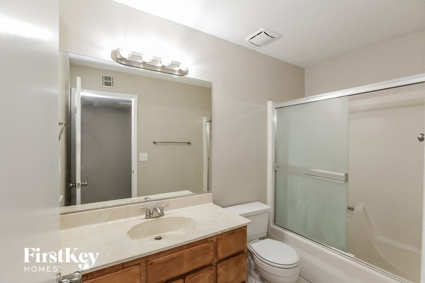 a bathroom with a large mirror and a toilet and a shower