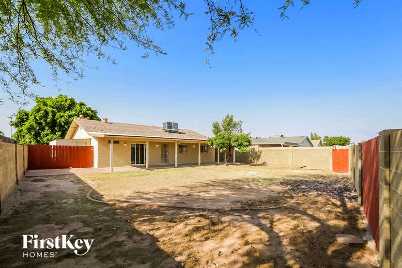 a house with a dirt yard and a fence