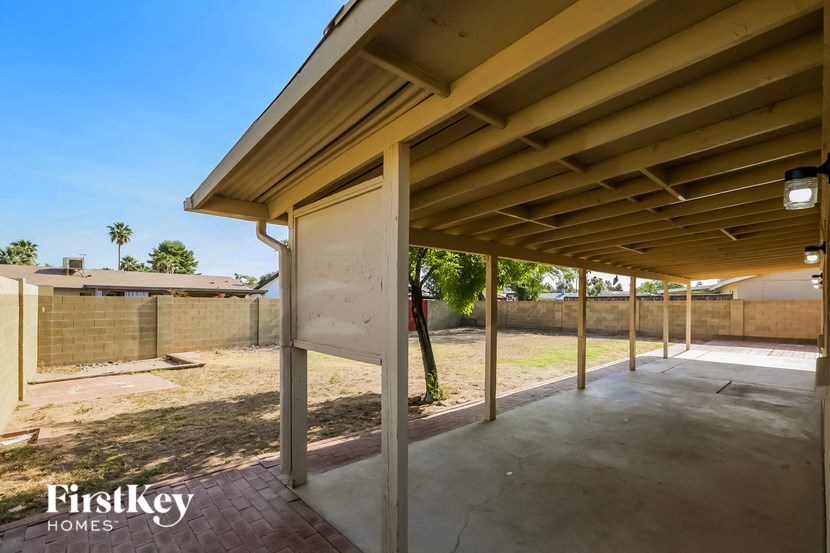a covered walkway under a building with a patio