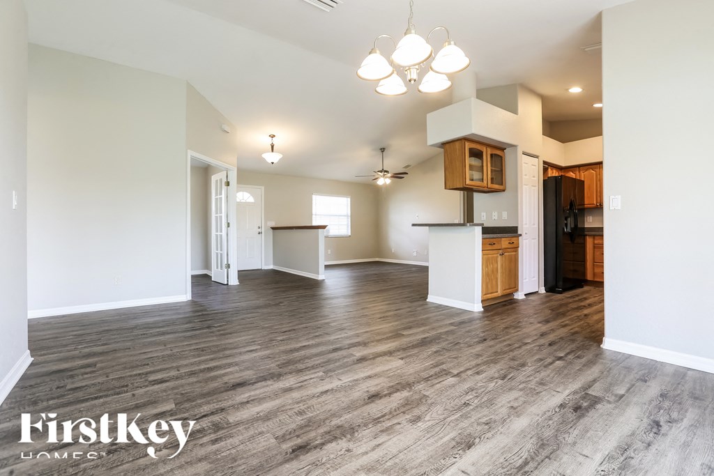 a kitchen and living room with wood floors and white walls