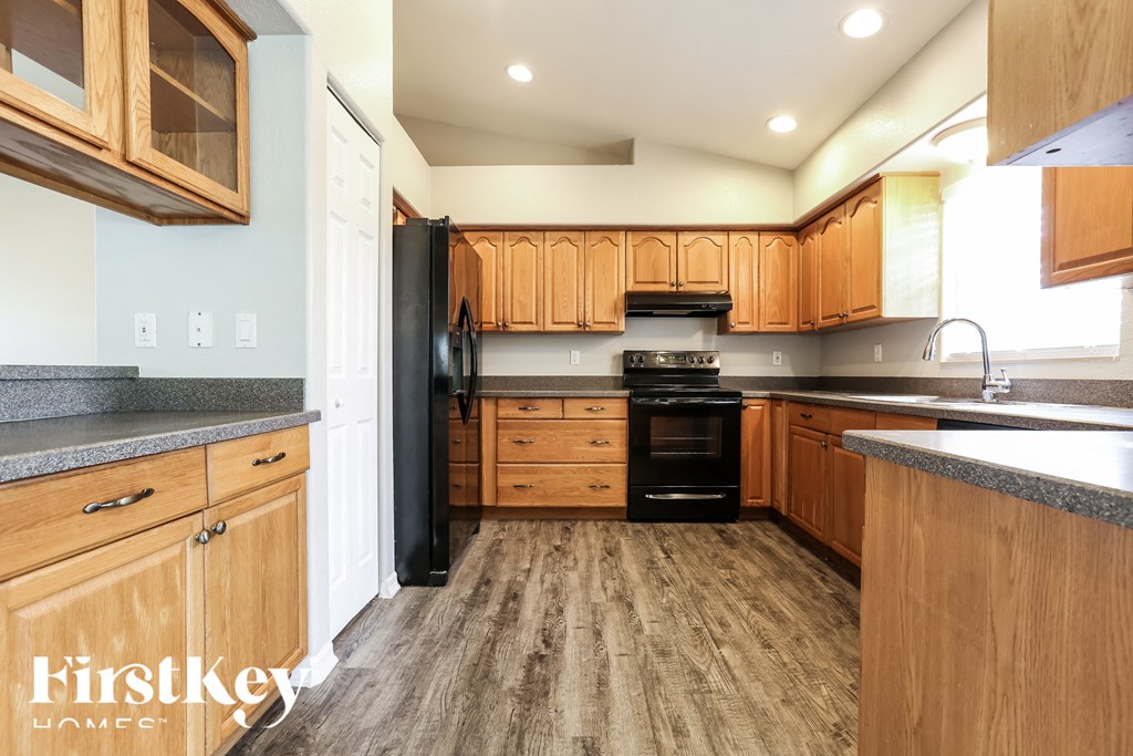 a large kitchen with wooden cabinets and black appliances