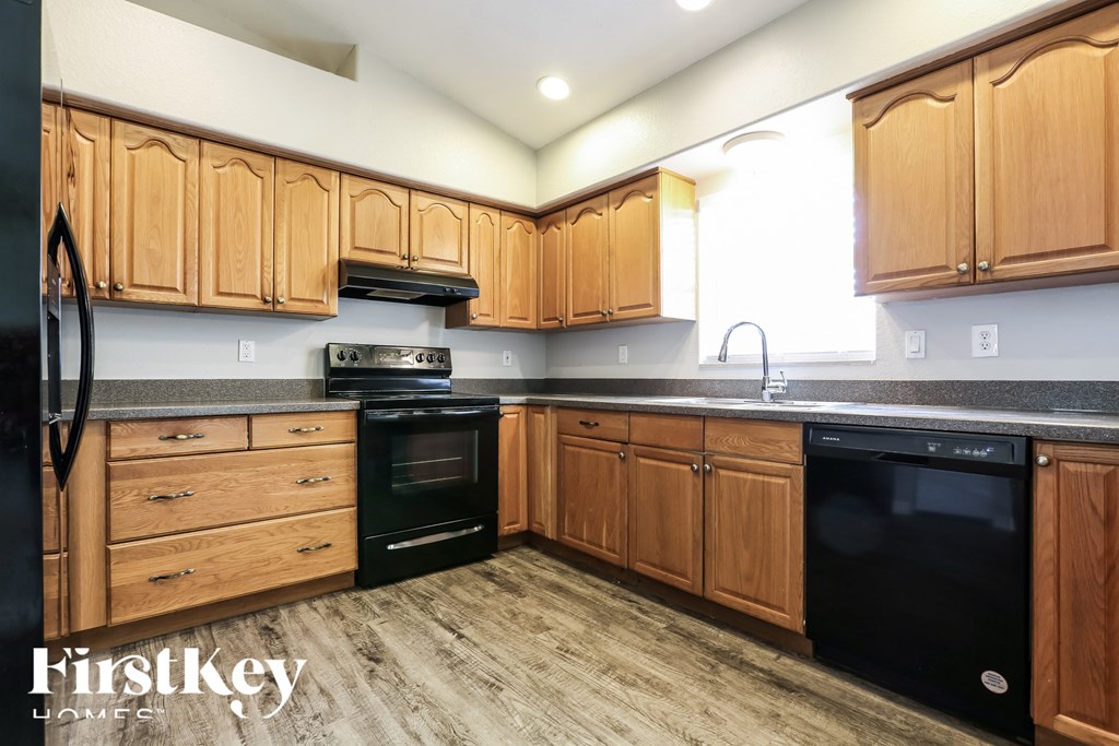 a kitchen with wooden cabinets and black appliances