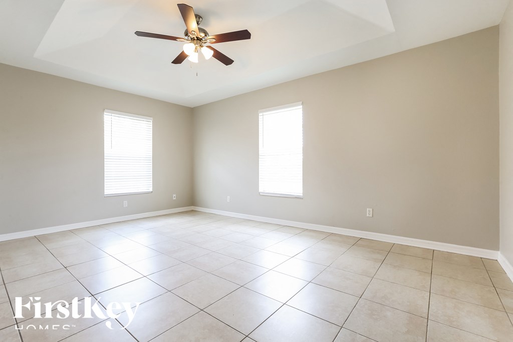 an empty living room with a ceiling fan