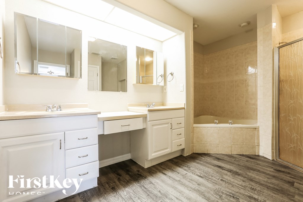 a bathroom with a large mirror and two sinks and a shower