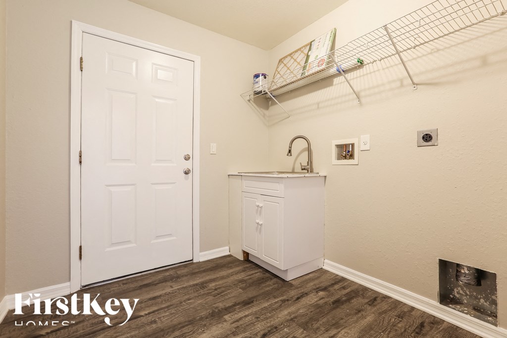 a utility room with a sink and a white door
