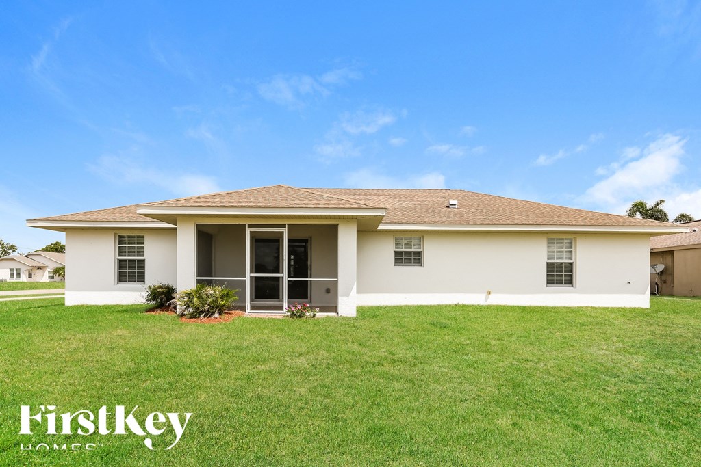 a beige house with a lawn in front of it