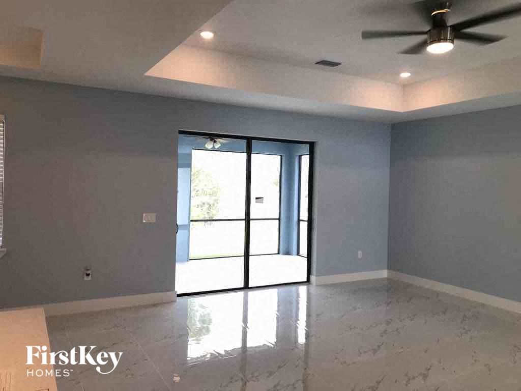 A room with a sliding glass door and a ceiling fan.