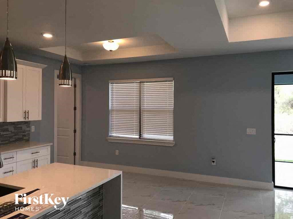 A kitchen with a countertop and a window with blinds.