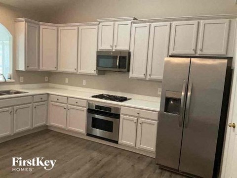 A kitchen with white cabinets and stainless steel appliances.