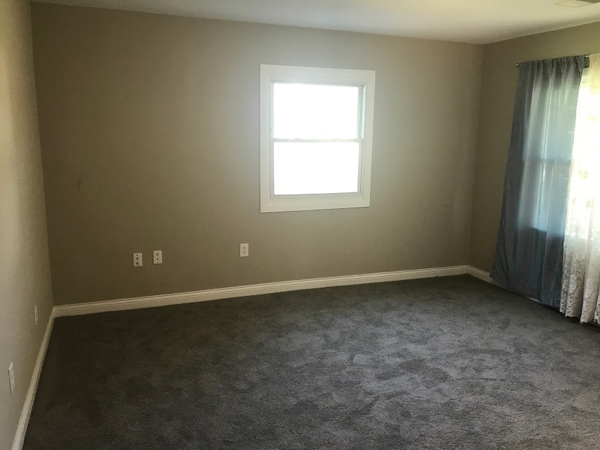 a empty room with a window and a curtain