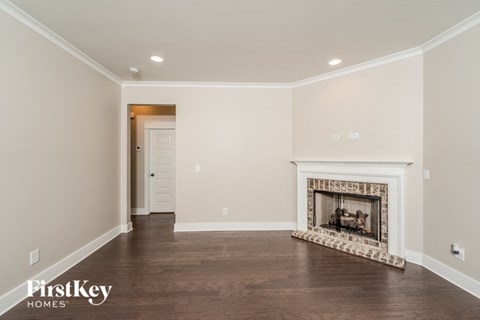 A spacious living room with a fireplace and wooden flooring.