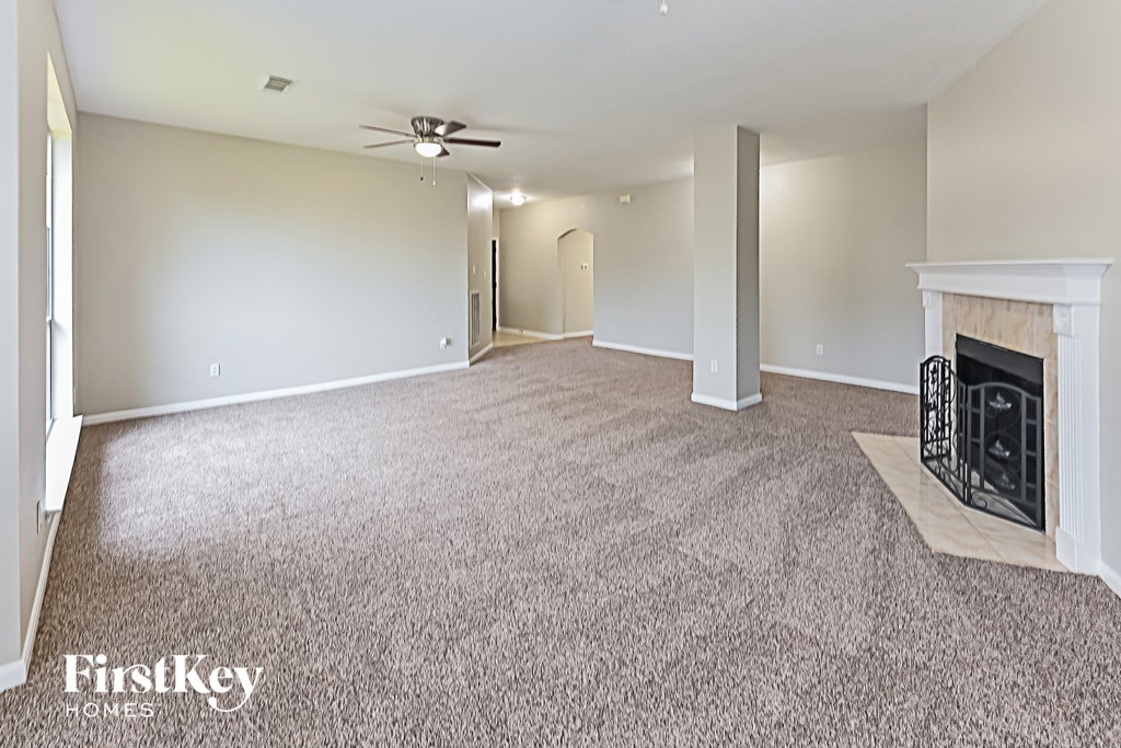 a living room with a fireplace and a carpeted floor