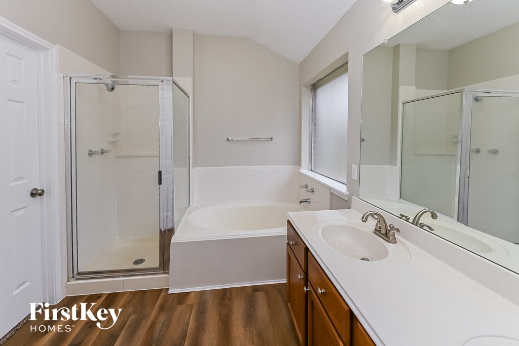 a bathroom with a tub and a shower and a sink