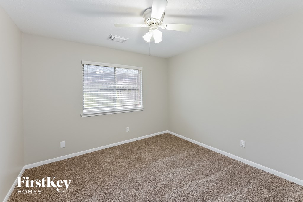 the master bedroom has a carpeted floor and a ceiling fan