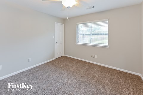 the living room of a home with carpet and a window