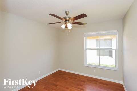 a bedroom with a ceiling fan and a window