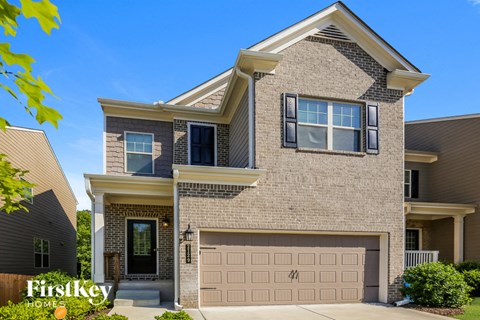 a tan brick house with a garage door