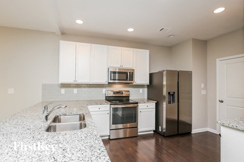 a kitchen with white cabinets and stainless steel appliances