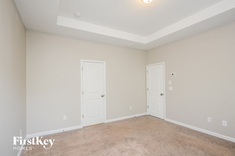 a bedroom with two doors and a carpeted floor