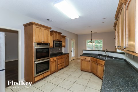 A kitchen with wooden cabinets and black countertops.