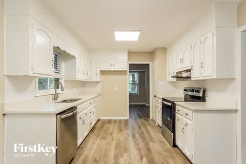 A kitchen with white cabinets and a stainless steel dishwasher.