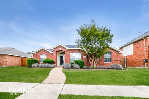 a brick house with a sidewalk in front of it