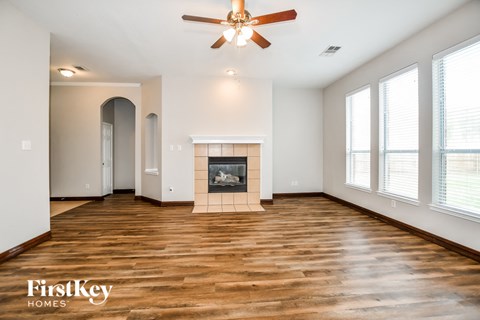 a living room with a fireplace and a ceiling fan