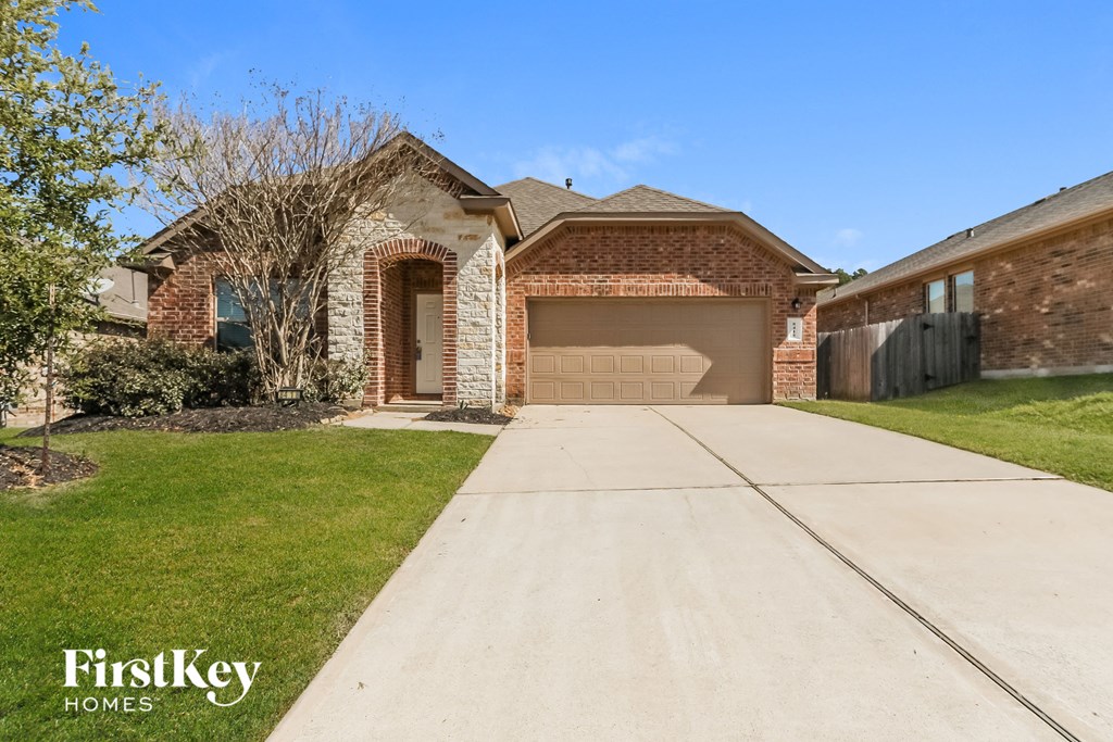 a brick house with a driveway and a garage door