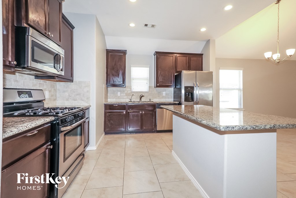 a kitchen with granite countertops and stainless steel appliances