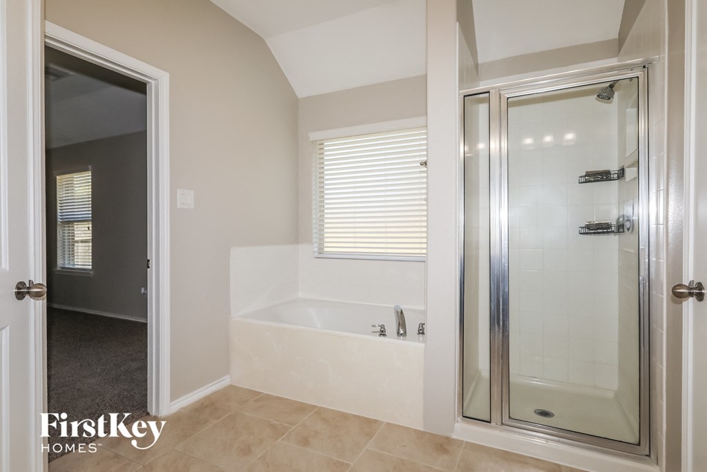 the master bathroom has a tub and a shower