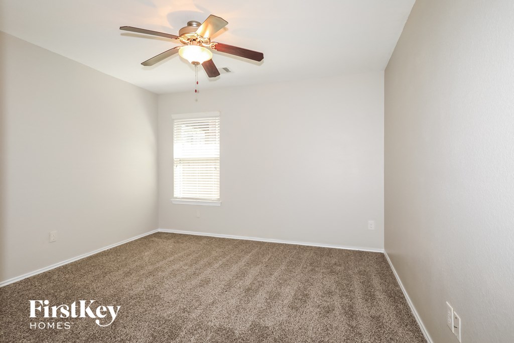 a room with carpet and a ceiling fan