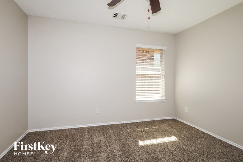 a room with carpet and a window and a ceiling fan